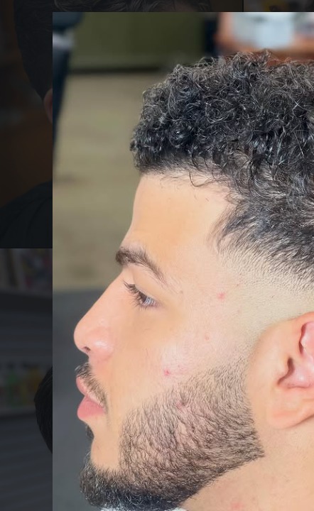 Curly top with drop fade and beard by Hozan